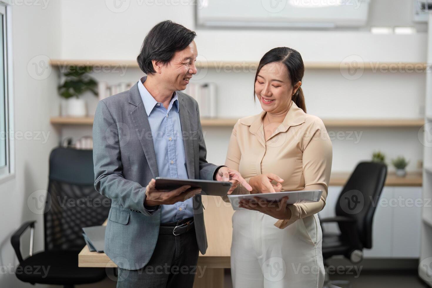 Team Collaboration and Document Sharing. Businessman and businesswoman discussing documents in a modern office. photo