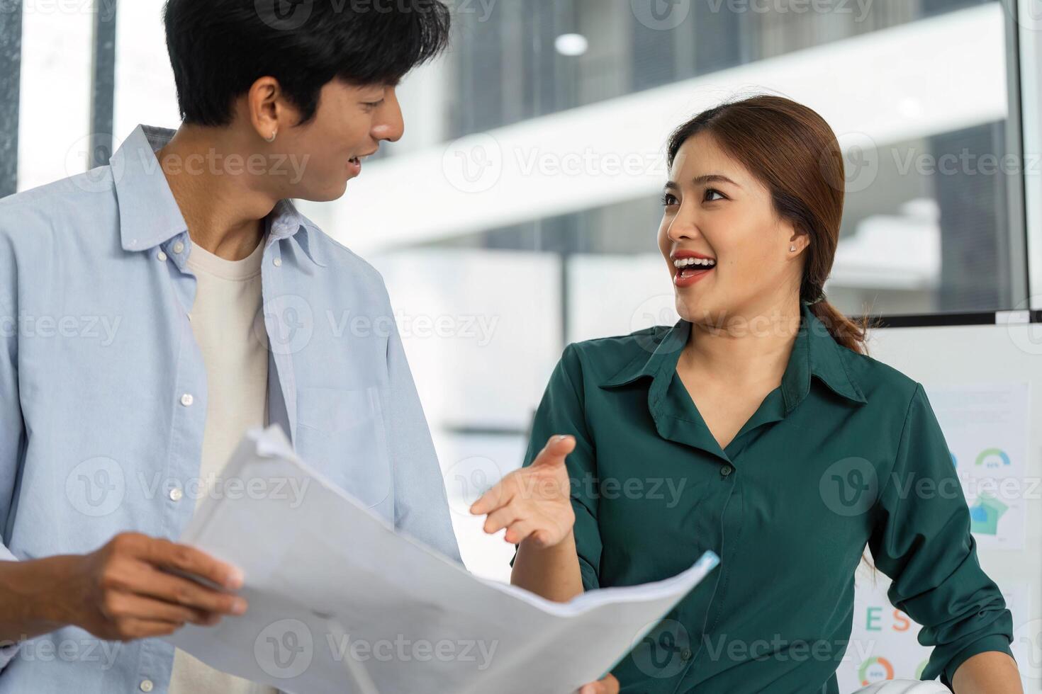 ESG and Sustainability. Two professionals discussing eco-friendly building plans in a modern office. photo