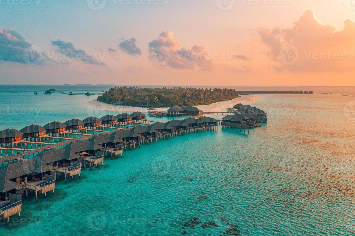 Stunning aerial view of Maldives island luxurious water villas surrounded by turquoise lagoon and white sandy beaches at sunset breathtaking tropical paradise perfect for serene escapes luxury travel photo