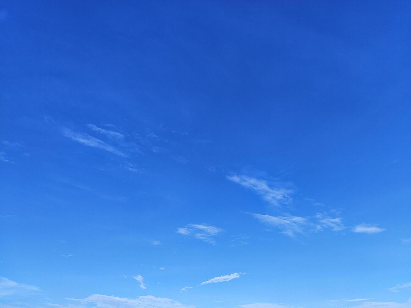Clear Blue Sky with Few White Clouds on a Sunny Day photo