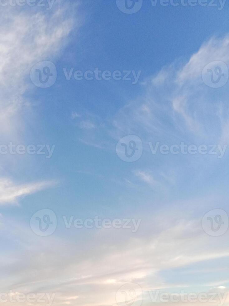 Soft white clouds drifting in a calm, clear blue sky photo