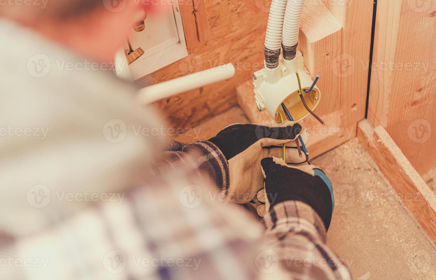 Electrician Wiring a Junction Box in a Residential Construction Project During Daylight Hours photo