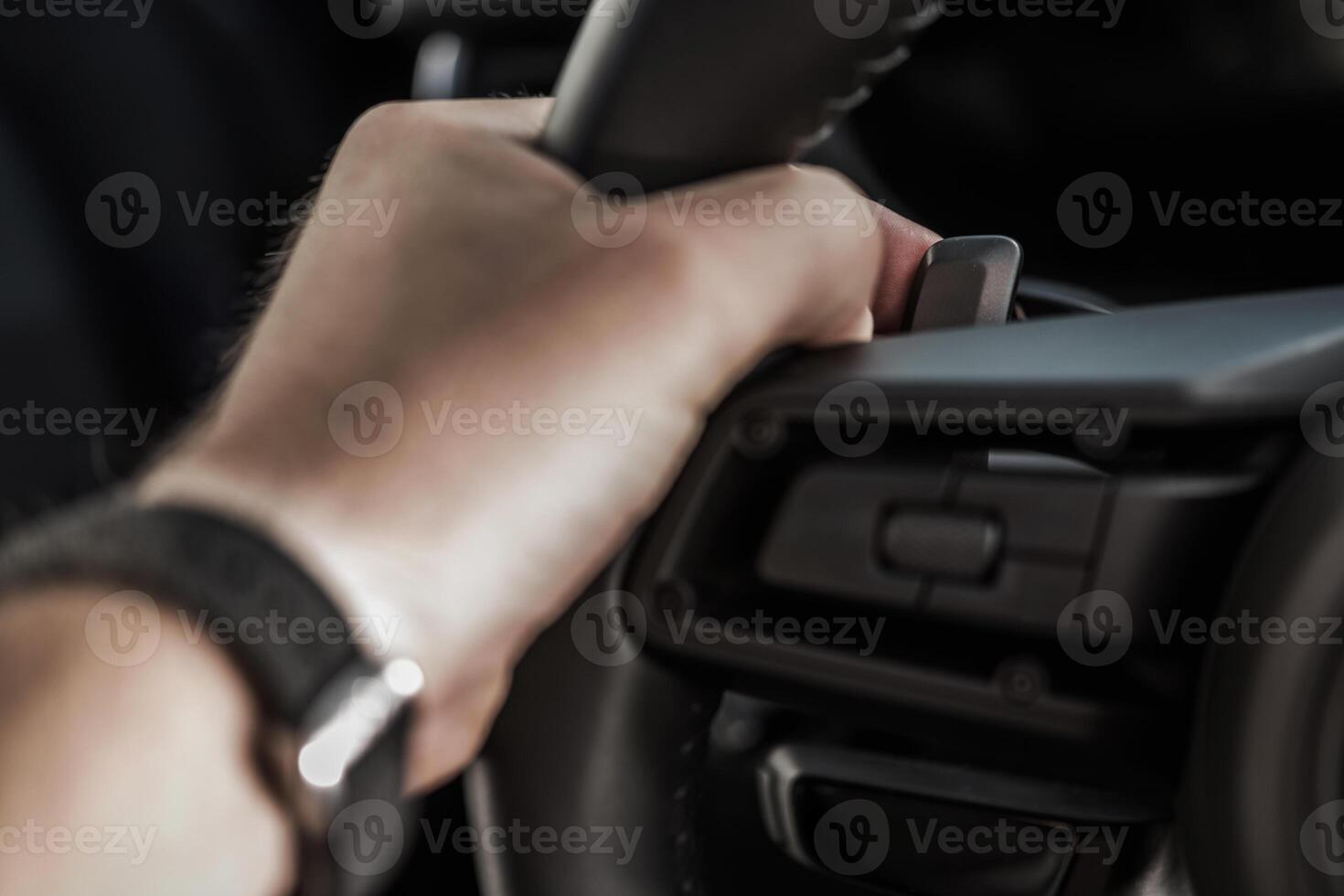 Hand Gripping Steering Wheel While Adjusting Gears Using Paddle Shifters photo