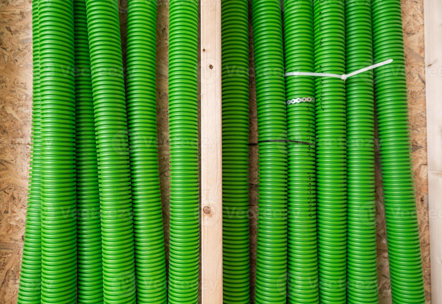 Bright Green Hoses Neatly Arranged on Wooden Shelves in a Storage Area photo