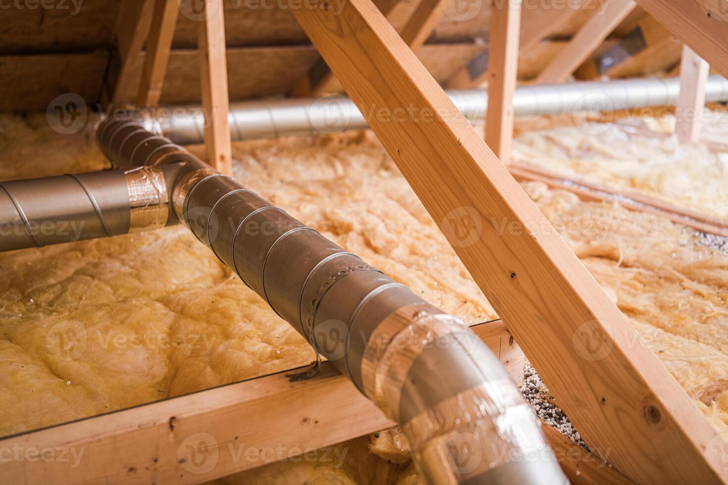 Ventilation Ducts Installed in Residential Attic With Insulation for Energy Efficiency During Winter Season photo