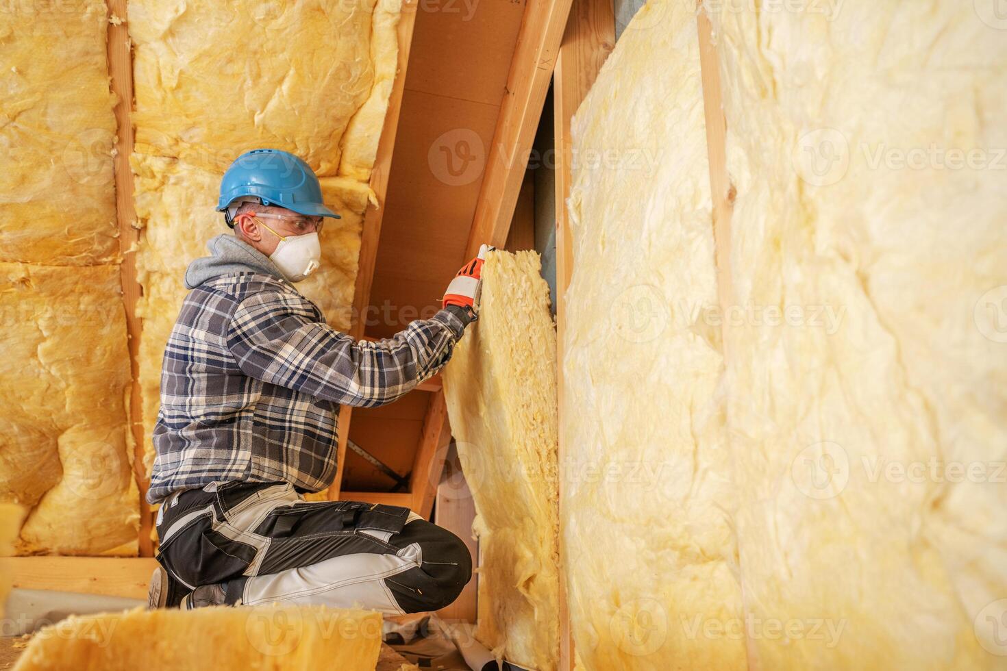 Worker Installs Insulation in Residential Attic During Home Renovation Project in Early Morning Light photo