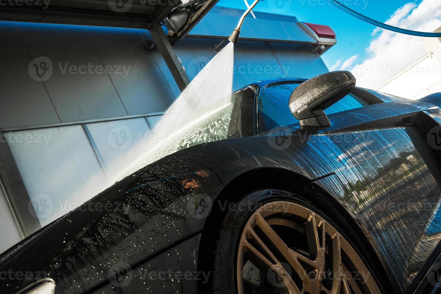 Luxury Sports Car Being Washed at a Car Wash Facility on a Sunny Day photo