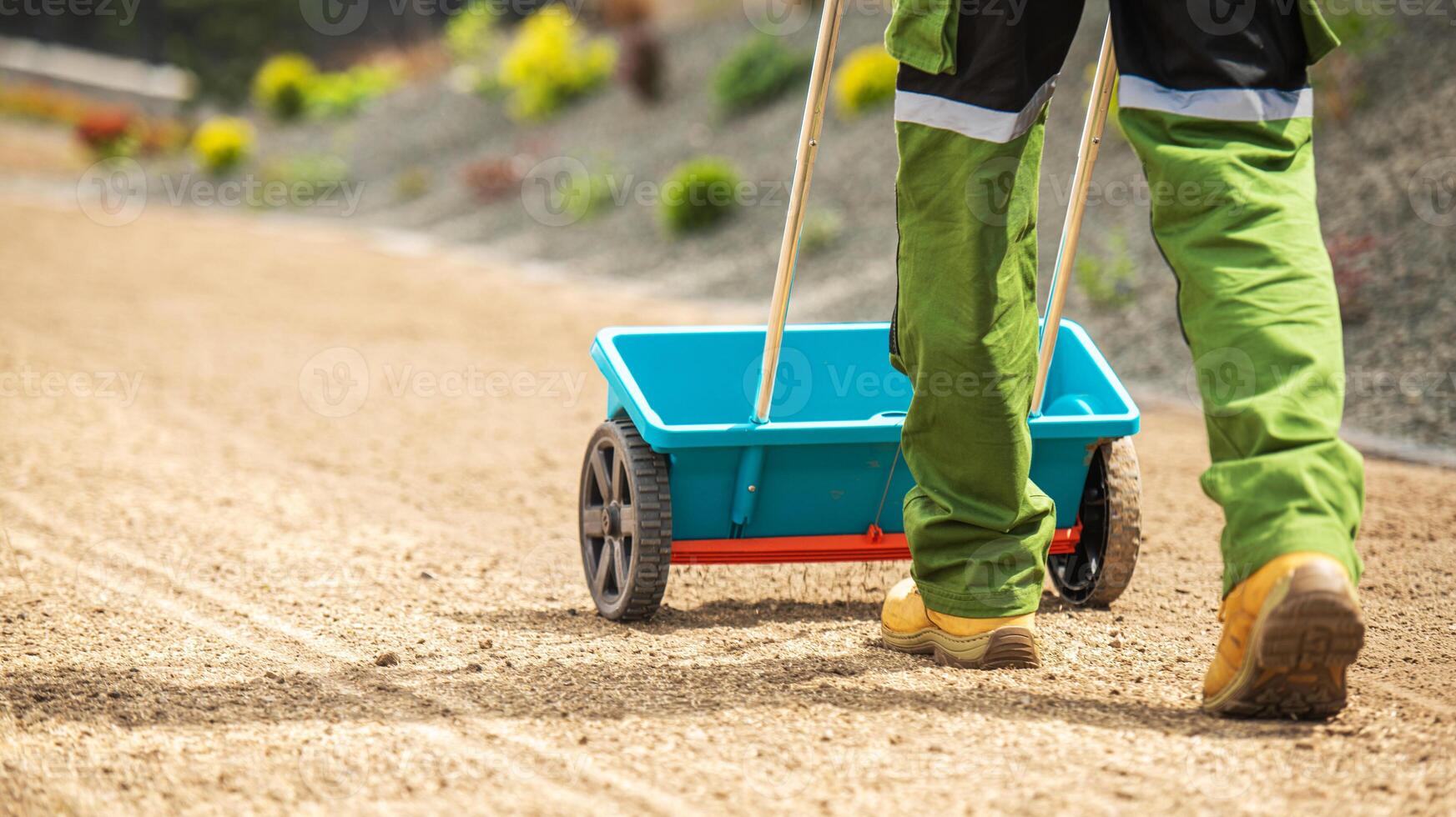 Worker Using a Wheelbarrow to Transport Materials on a Construction Site in Bright Green Work Attire photo