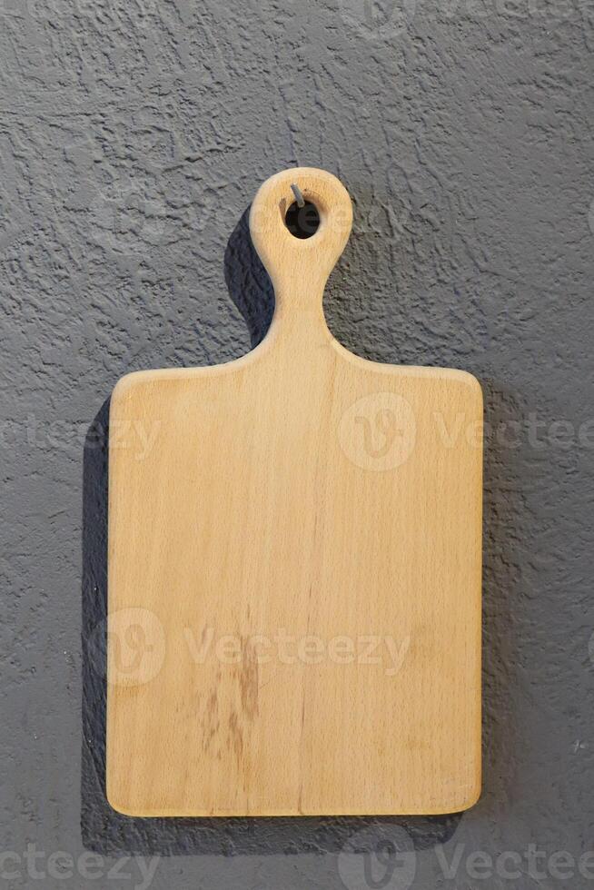A Rustic Wooden Cutting Board beautifully displayed on a charming Grey Wall for decor photo