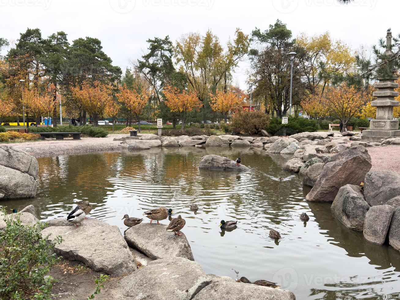 Autumn park path, cloudy sky and leaves photo