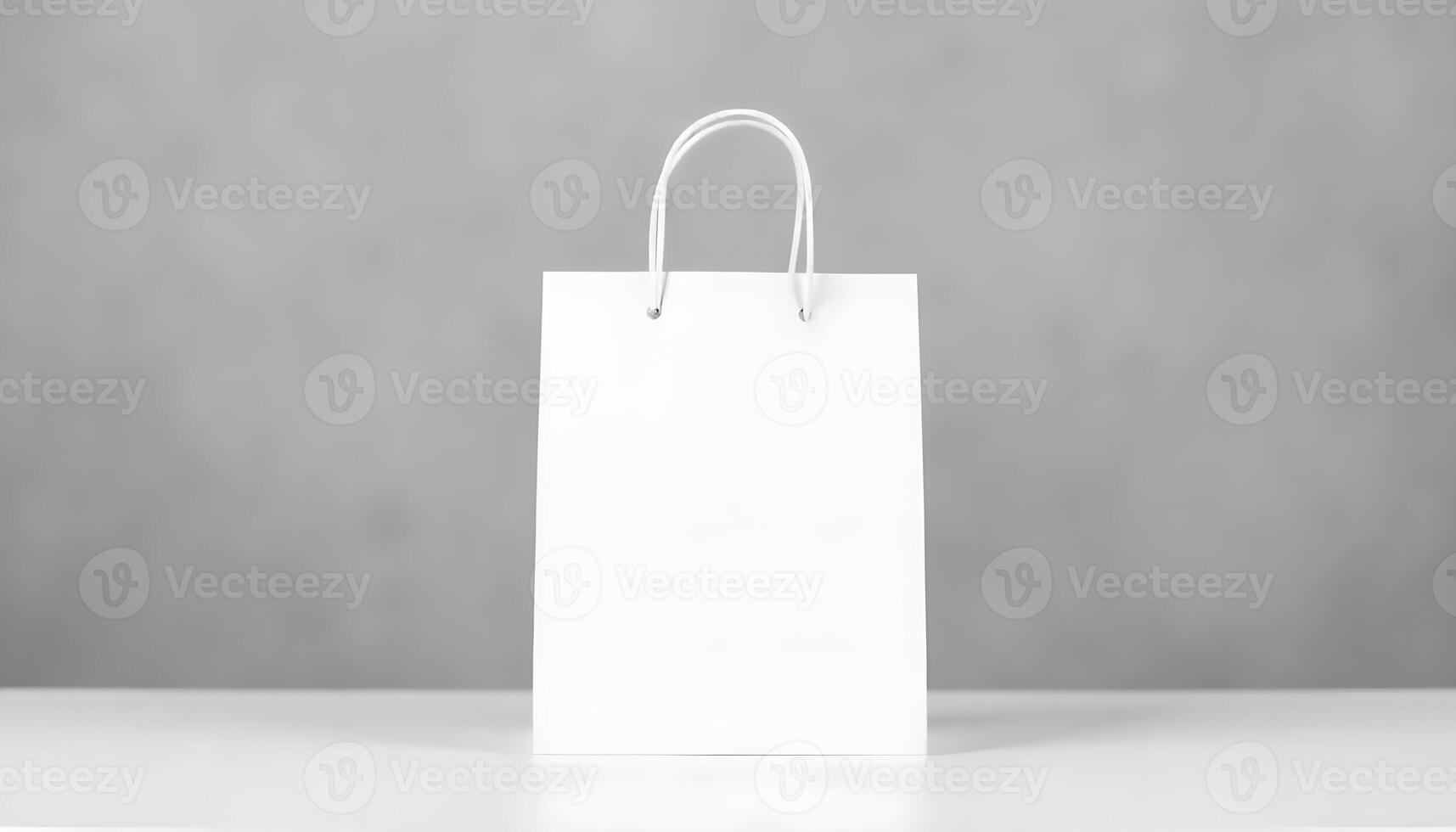 A pristine white paper shopping bag with elegant handles sits on a smooth, white surface. photo