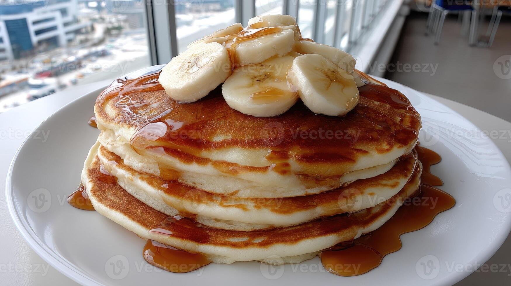 A stack of pancakes topped with bananas and syrup photo