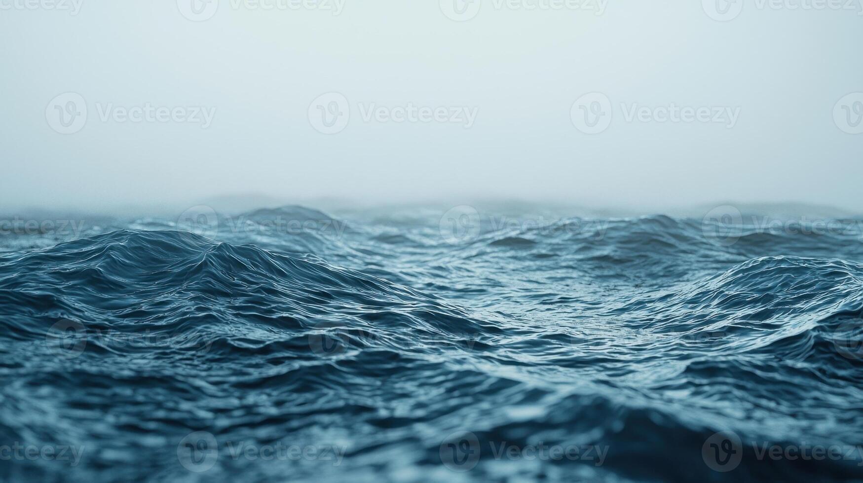 Waves move steadily, creating a rhythmic sound as they wash against the shore. The fog envelops the scene, adding a mysterious atmosphere to the tranquil morning photo