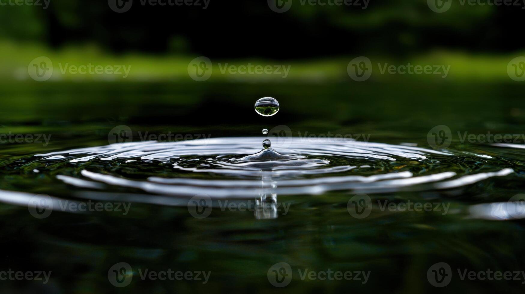 A drop of water is falling into the water photo