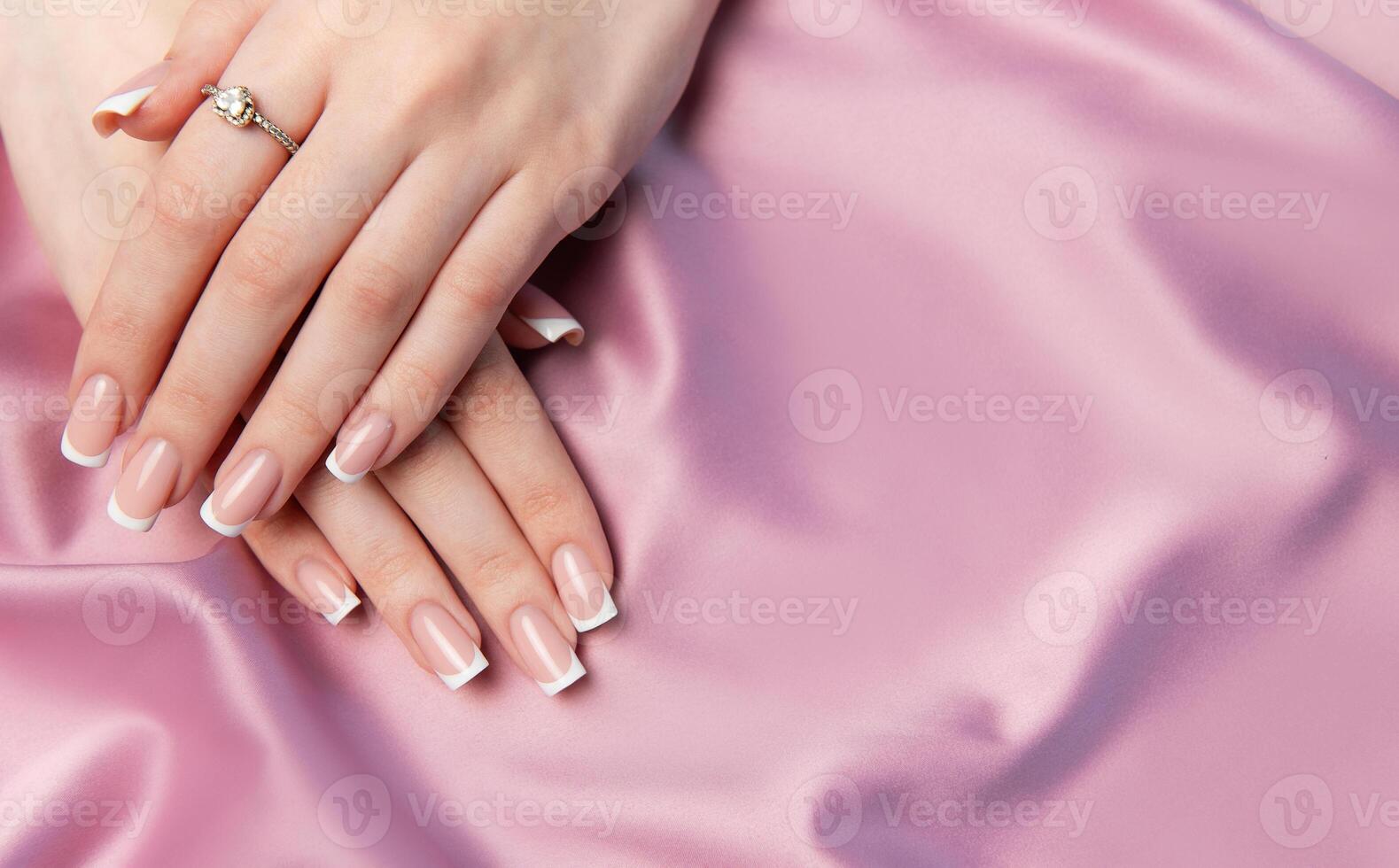 Woman showing manicure on pink satin background photo