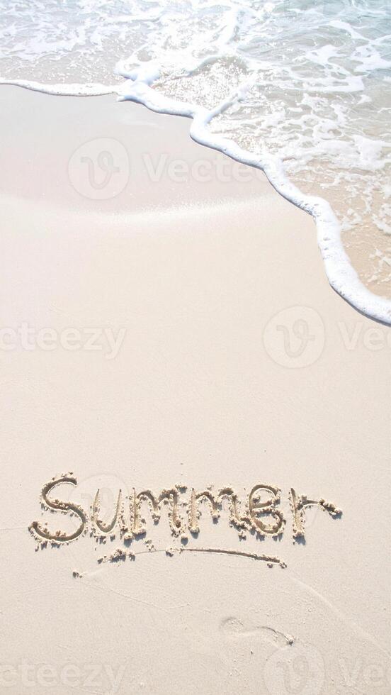 summer background with finger written text on sand and wave photo