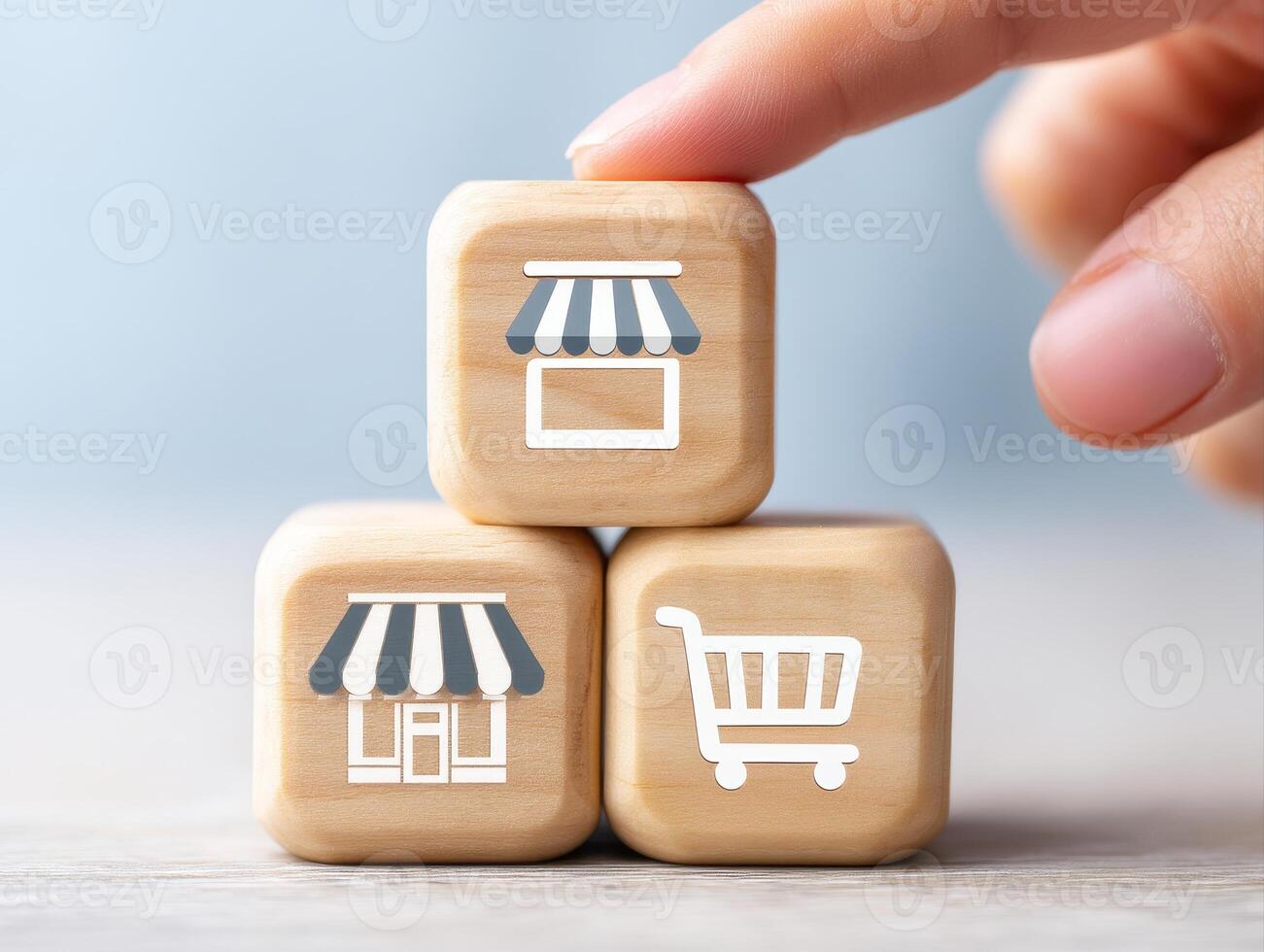 Hand stacking wooden cubes with storefront and shopping cart icons symbolizing retail and commerce concepts in soft light photo
