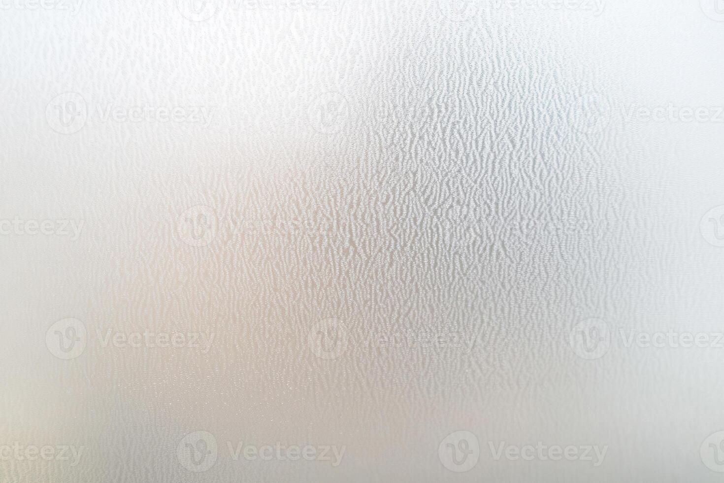 Close-up view of a textured white surface, possibly a wall or appliance, with light variations photo
