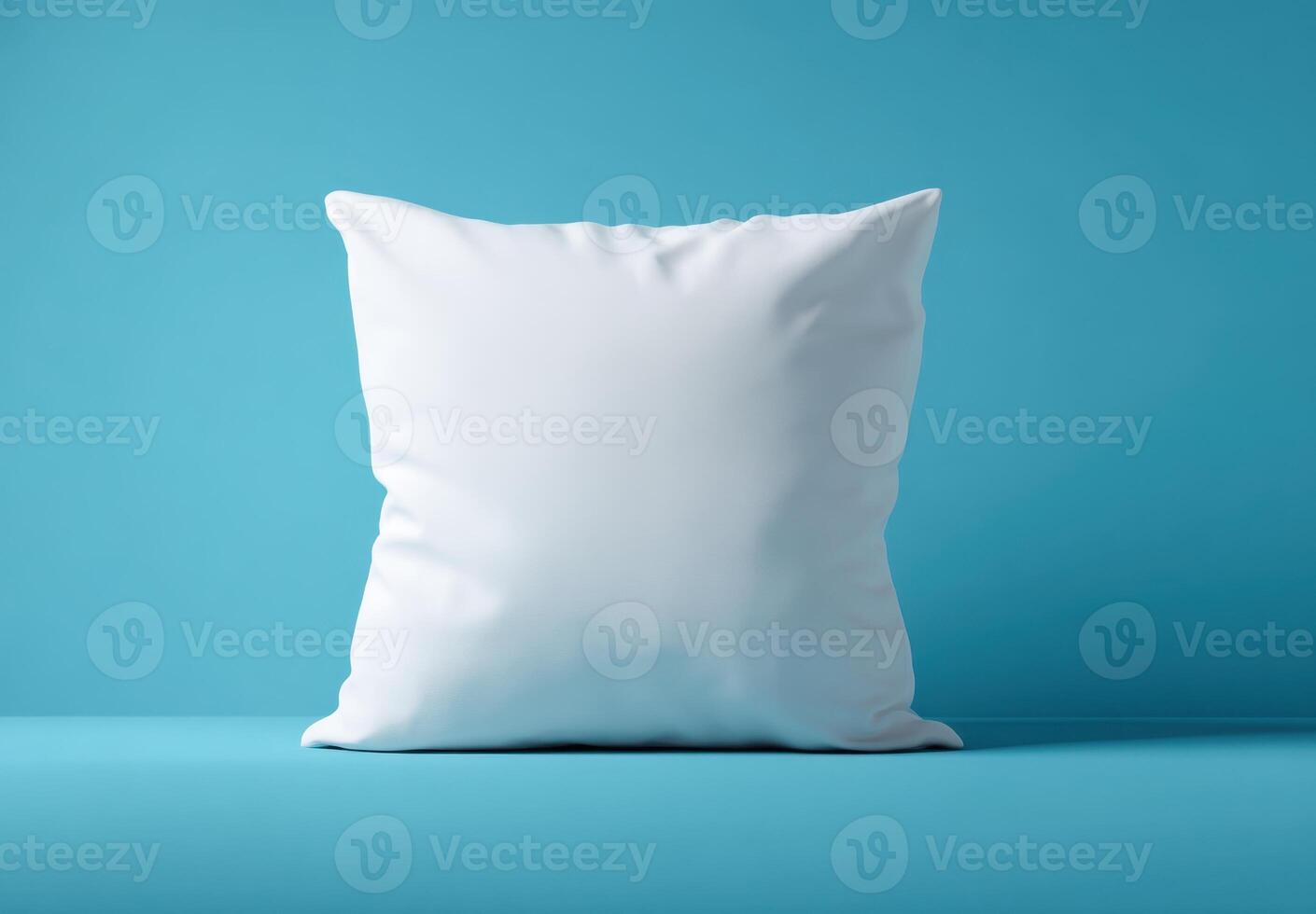 Soft white pillow resting against a bright blue background, perfect for showcasing textile designs or simple home comfort concepts. photo