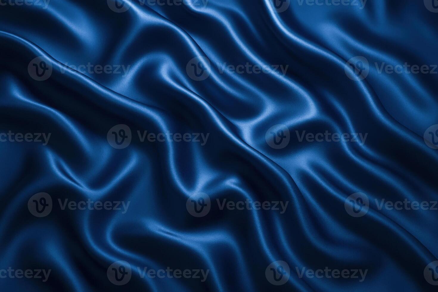 A close-up view of deep blue satin fabric with smooth, flowing folds. The texture appears soft and luxurious, showcasing the sheen of the material. photo