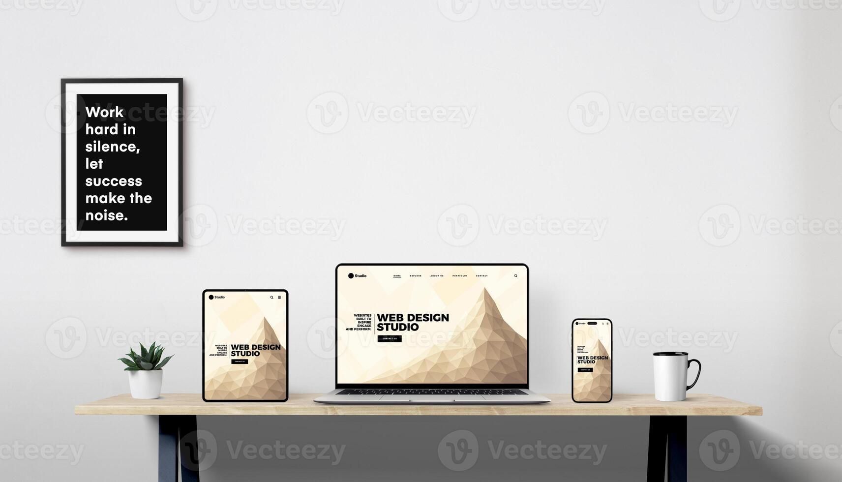 Responsive web design displayed on laptop, tablet, and phone in modern workspace with plant, coffee mug, and framed motivational quote photo