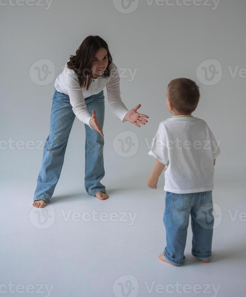 The stark white cyclorama amplifies the echoes of laughter as a mother and her son chase each other. photo
