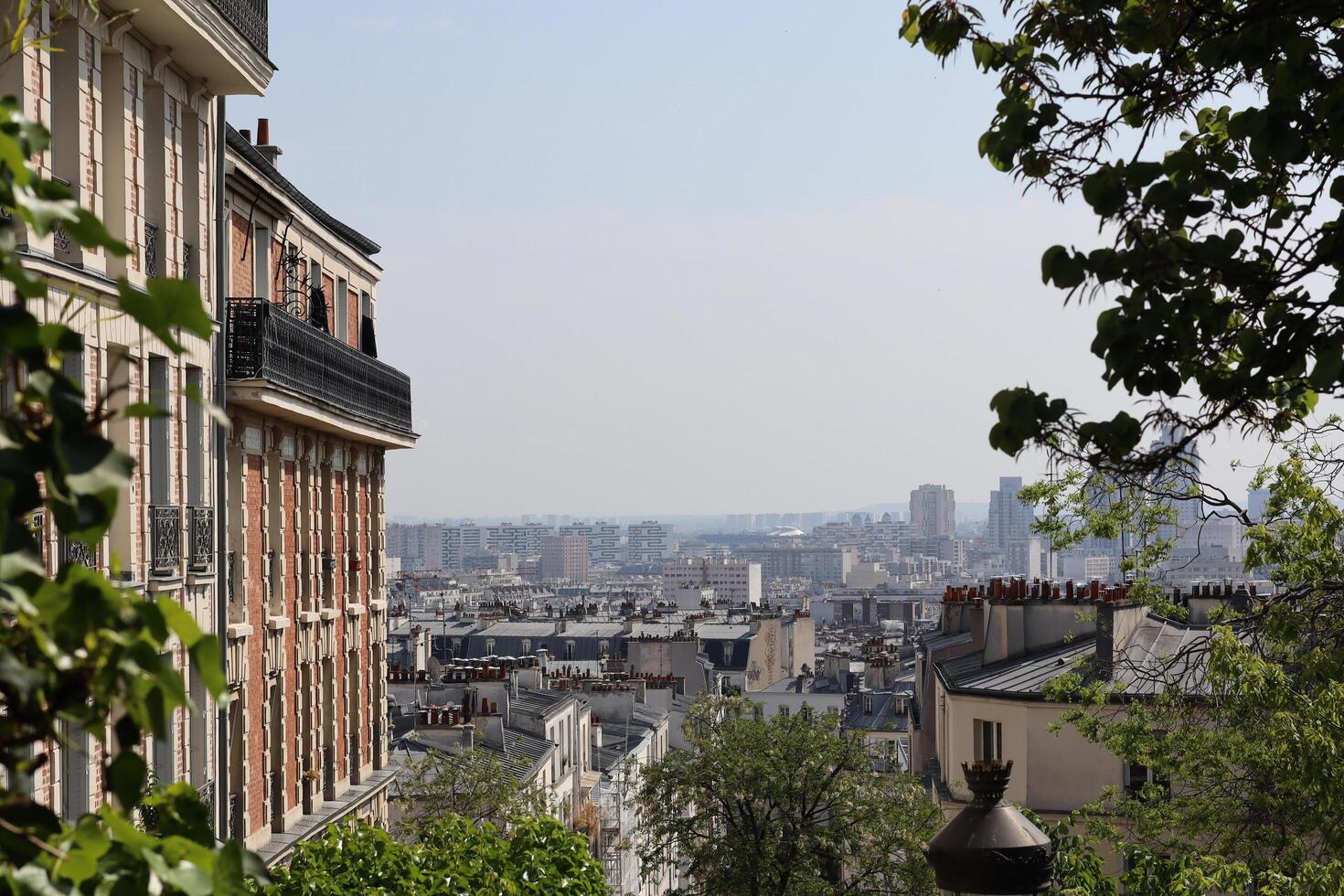Beautiful view of Parisian rooftops from a hillside in warm sunlight, showcasing the city's iconic architecture and skyline photo