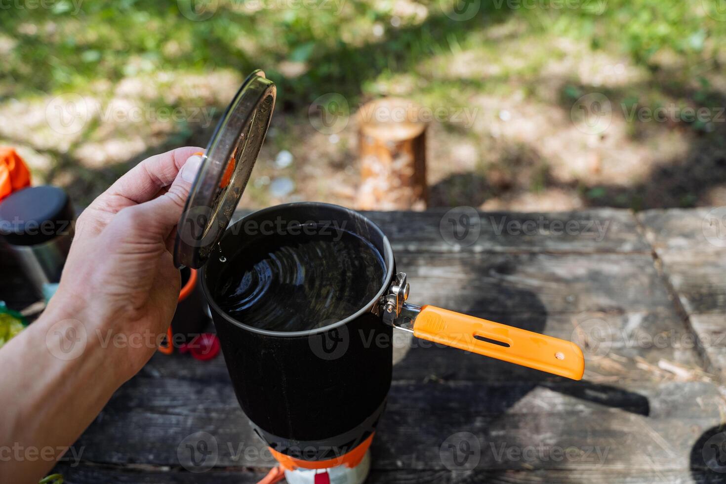 Enjoy the delightful experience of outdoor cooking imagine a pot simmering on a camp table set amidst breathtaking nature, creating an adventurous culinary journey under the vast open sky photo