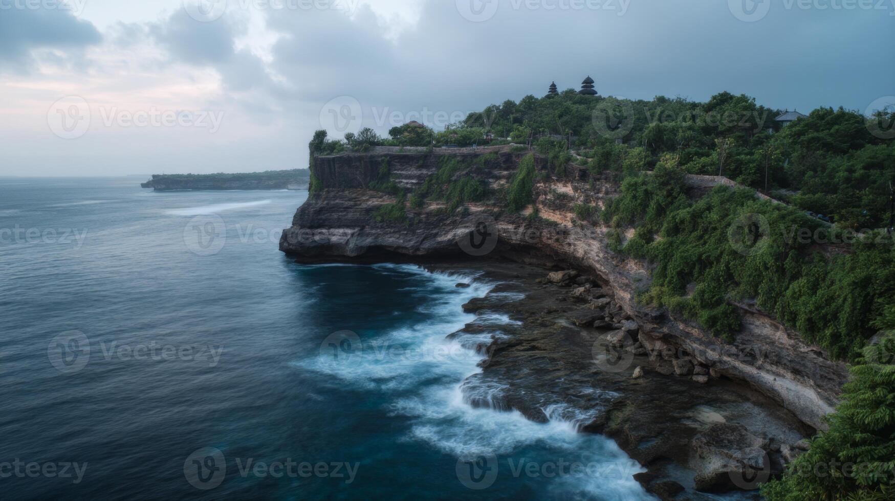 Serene Coastal Landscape with Cliffside Vegetation and Gentle Ocean Waves at Sunset in Bali, Indonesia photo
