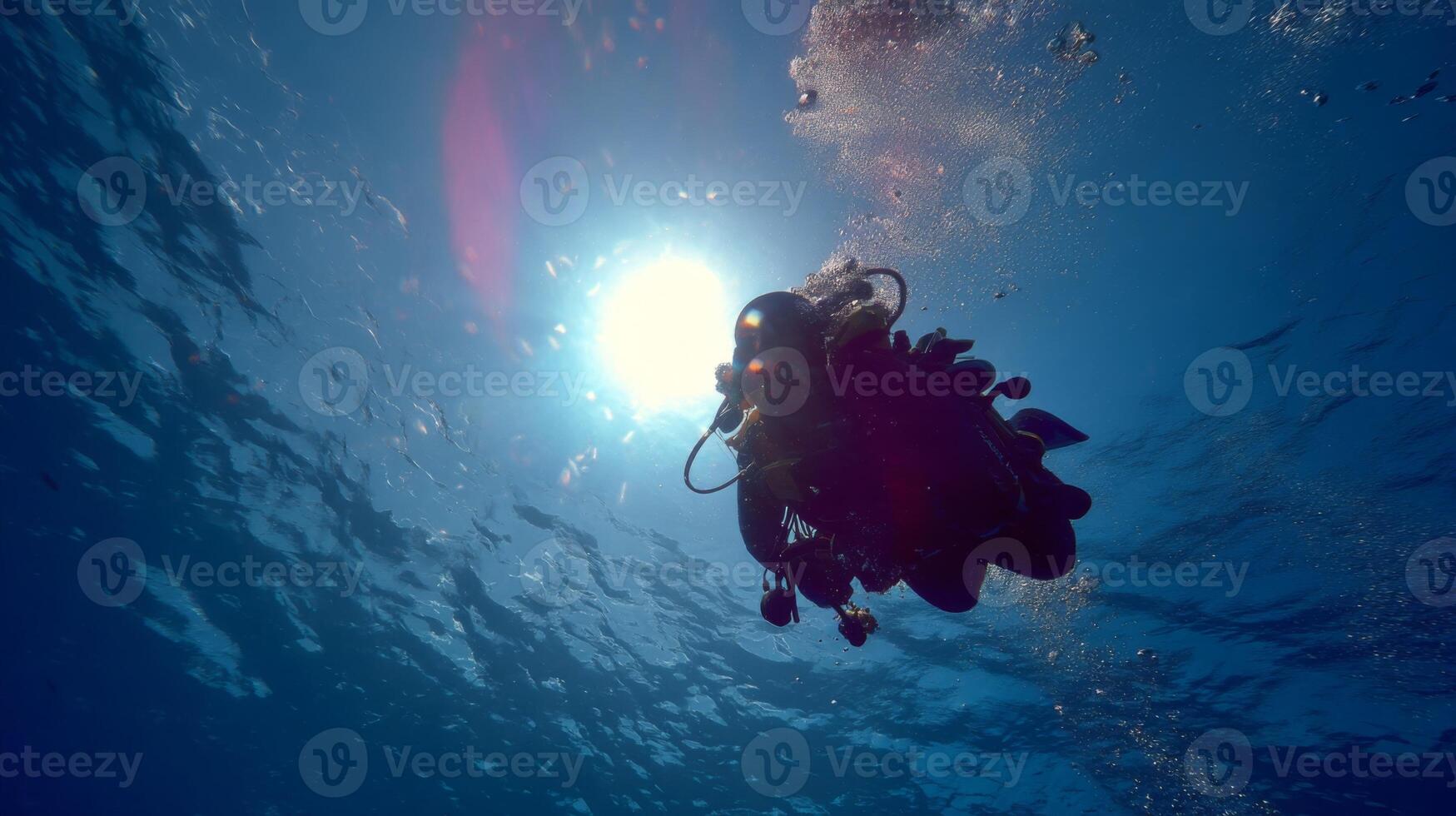 Underwater Exploration with Diver Silhouette Against Sunlight in Clear Blue Ocean Water photo
