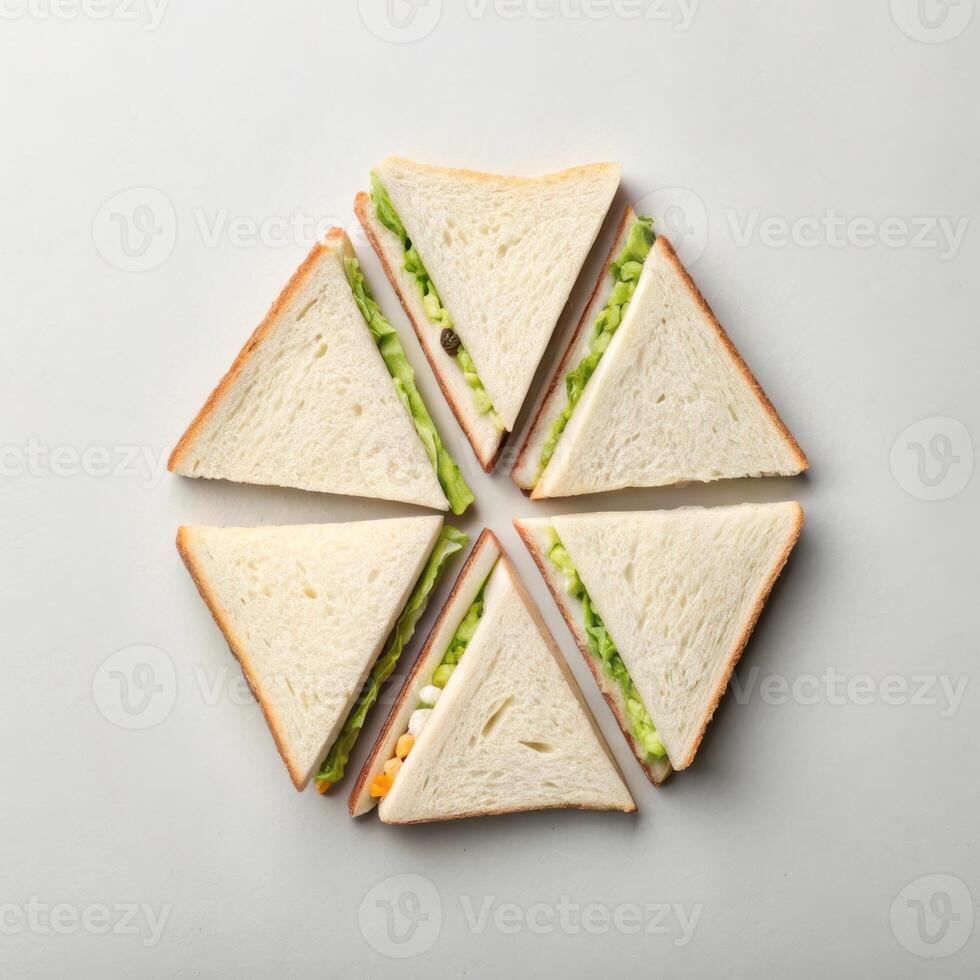 Triangular sandwiches arranged in circular pattern on light background with copy space photo