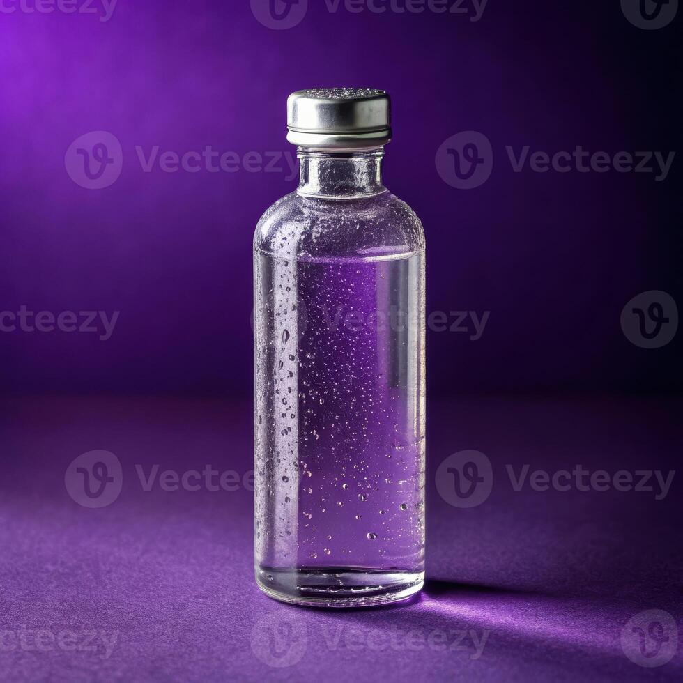 Clear glass bottle with water bubbles on dark purple background with refreshing mood and copy space photo