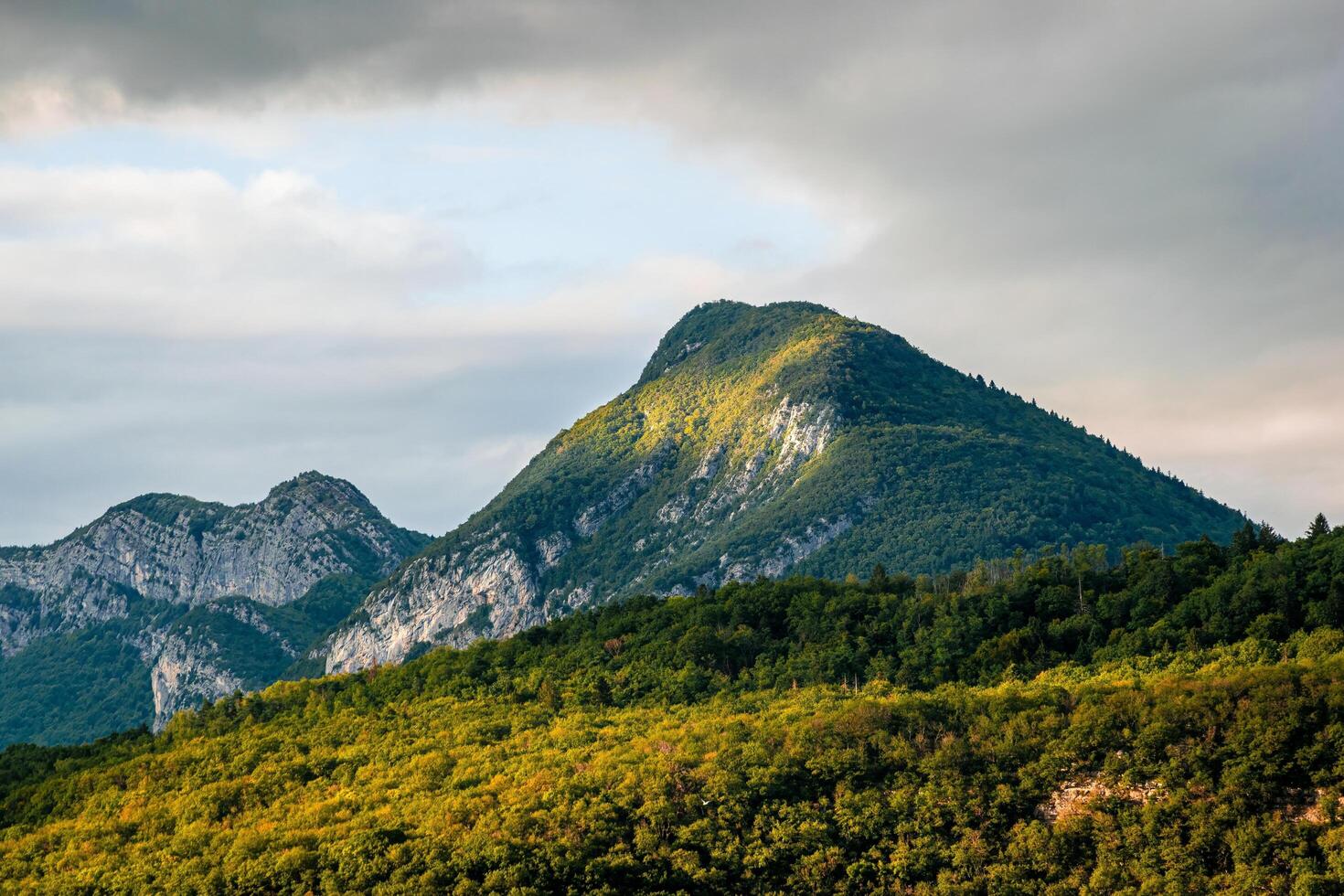 the mountains are covered with green trees and grass photo
