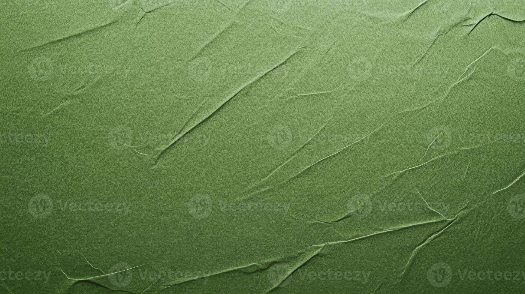 Textured olive green surface with creases creating an abstract design of light and shadow photo
