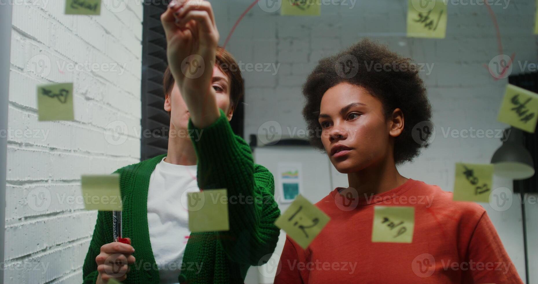 Two women standing in front of a wall with sticky notes photo