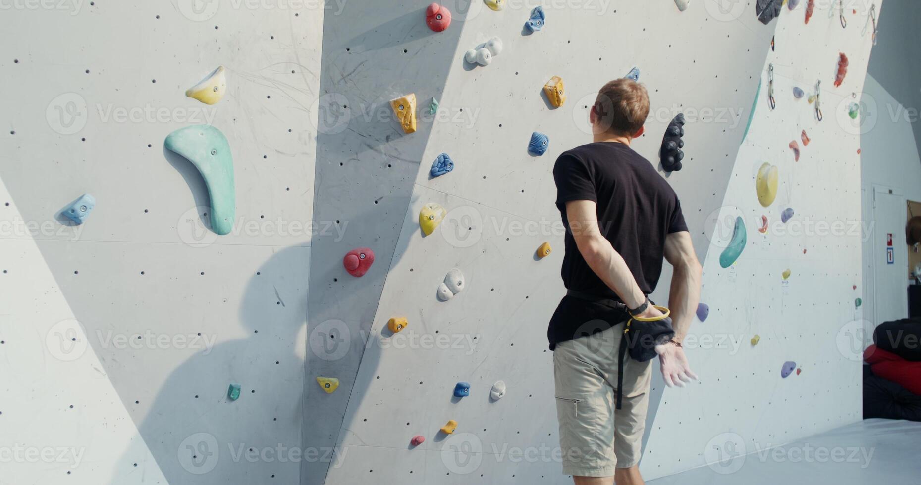A man is climbing on a climbing wall photo