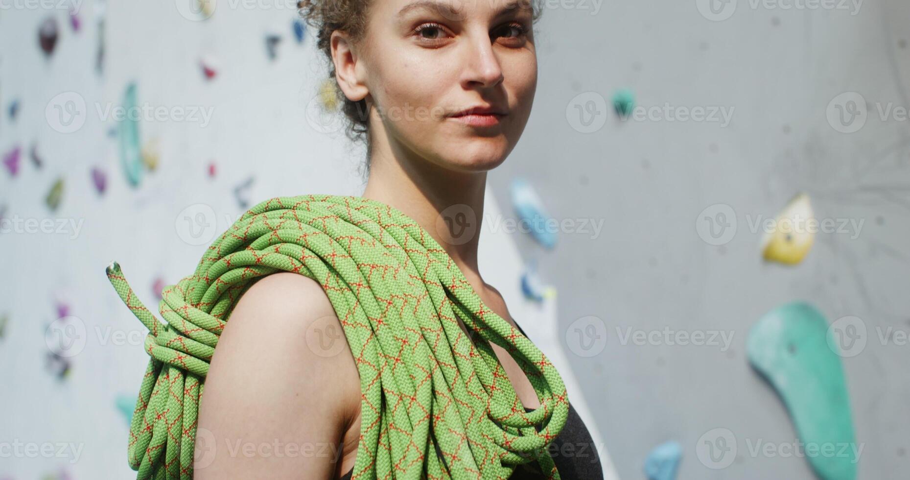A woman is holding a green climbing rope photo