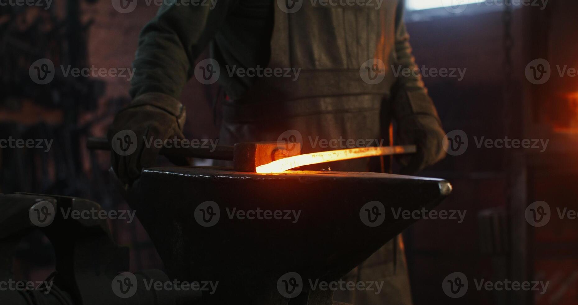 A man is working on a blacksmithing anvil photo