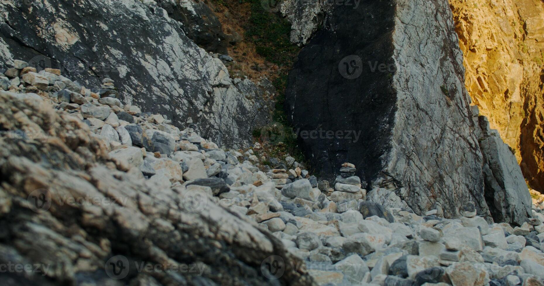 A man is walking up a rocky cliff photo