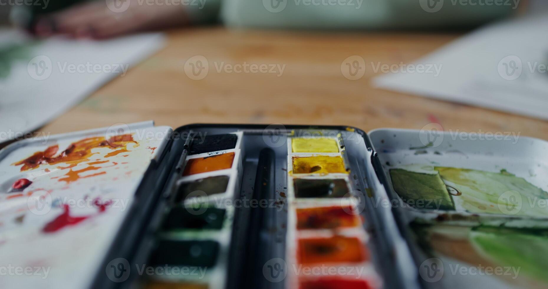 Close-up of watercolor paints lying on the artist's desk photo
