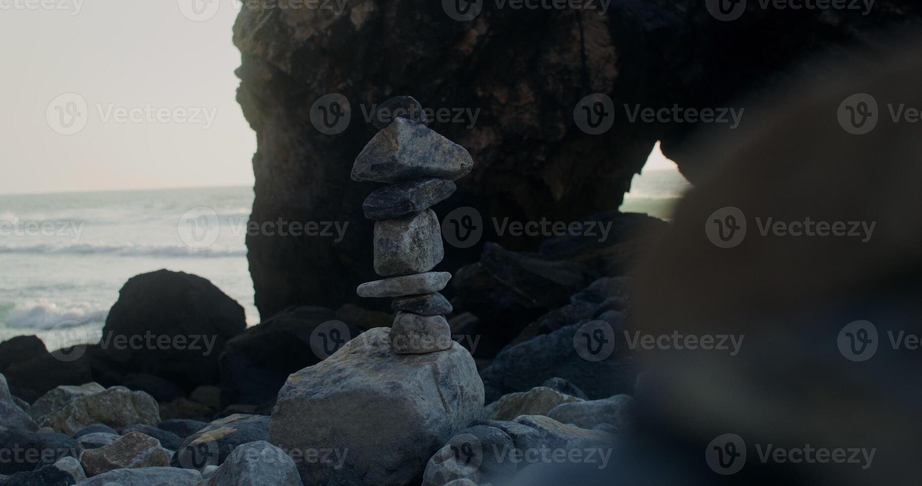 A stack of rocks on the beach near the ocean photo