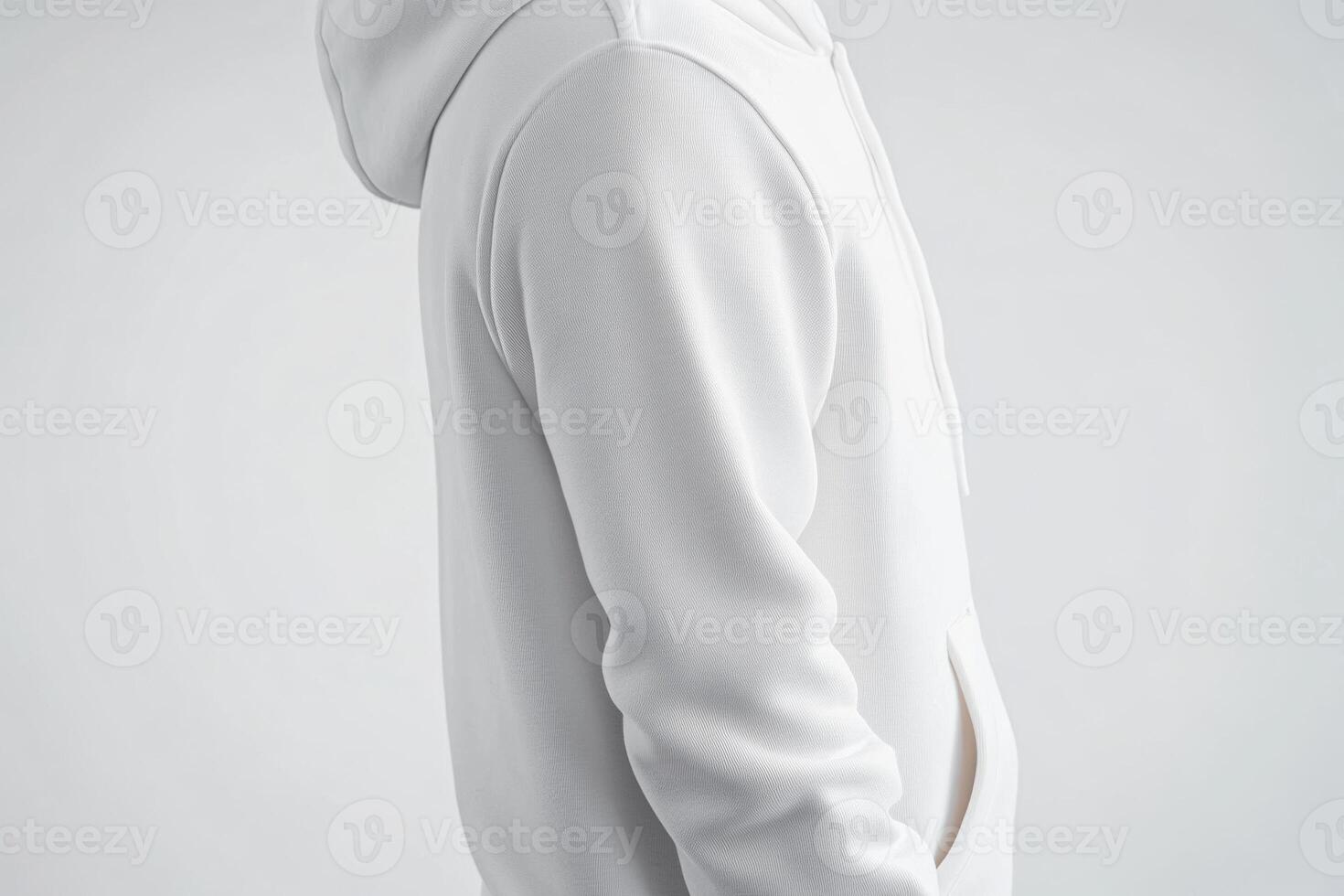 A man in a white hoodie standing with his hands on his hips photo