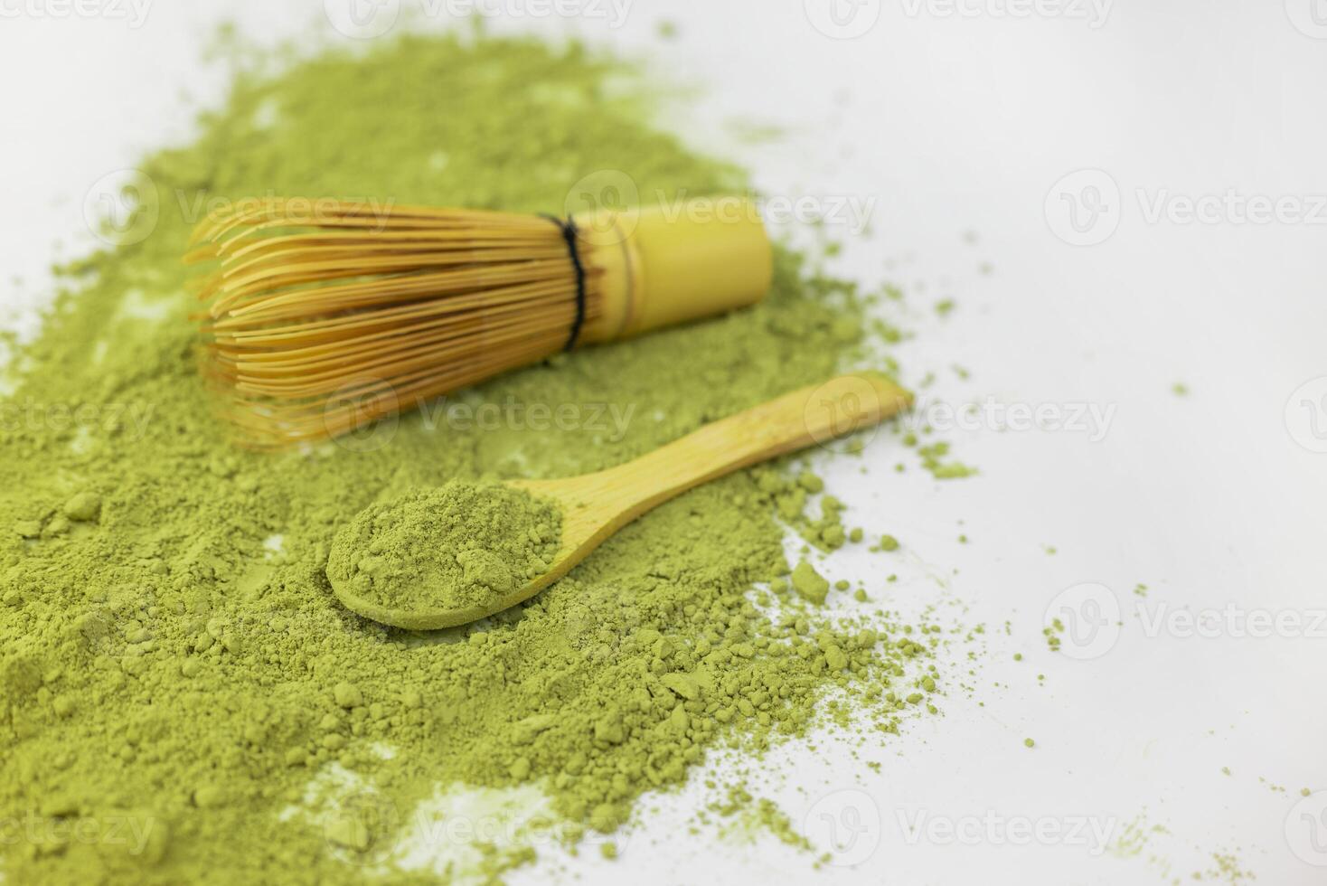 matcha green detox tea scattered with dry wooden spoon and bamboo whisk photo