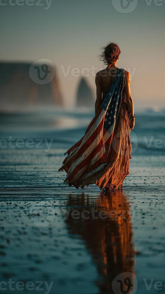 Woman in American flag dress walking along the beach at sunset photo