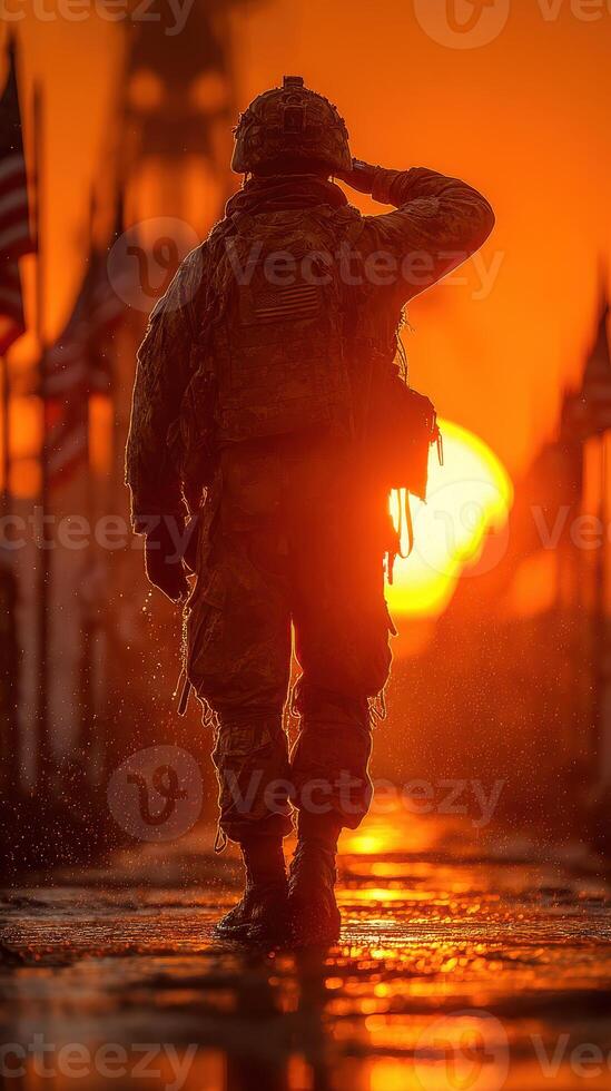 Soldier saluting during sunset at a military memorial site with flags in the background photo