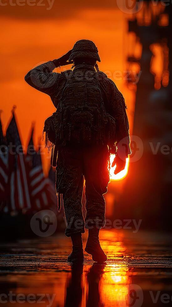Soldier saluting at sunset with American flags in the background during a military ceremony near a naval ship photo