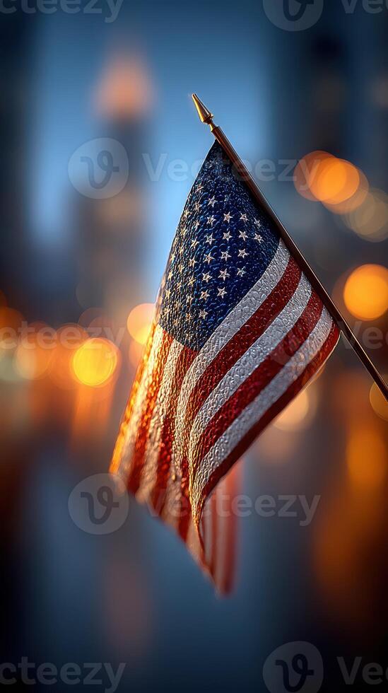 American flag waves proudly against a blurred city background during twilight hours photo