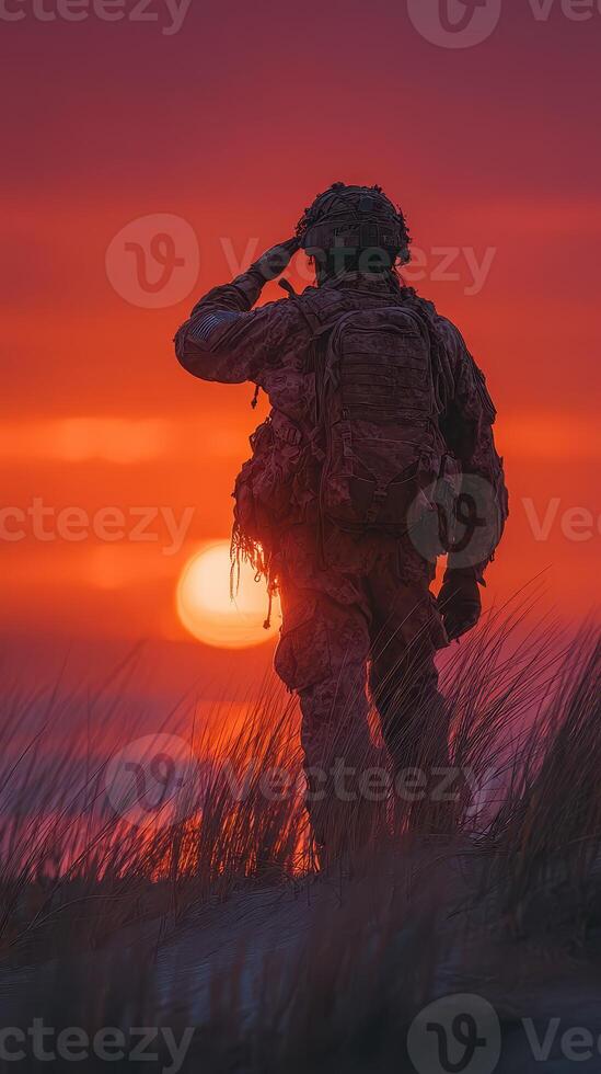 Soldier saluting at sunset on a beach, honoring the fallen while surrounded by tall grass and vibrant colors in the sky photo