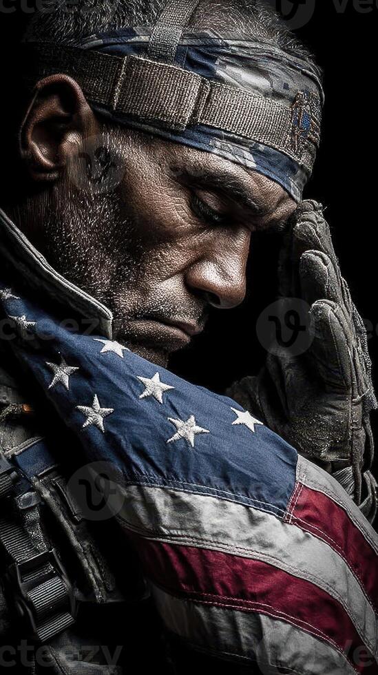 Soldier honoring fallen comrades while draped in American flag during a solemn moment of reflection photo