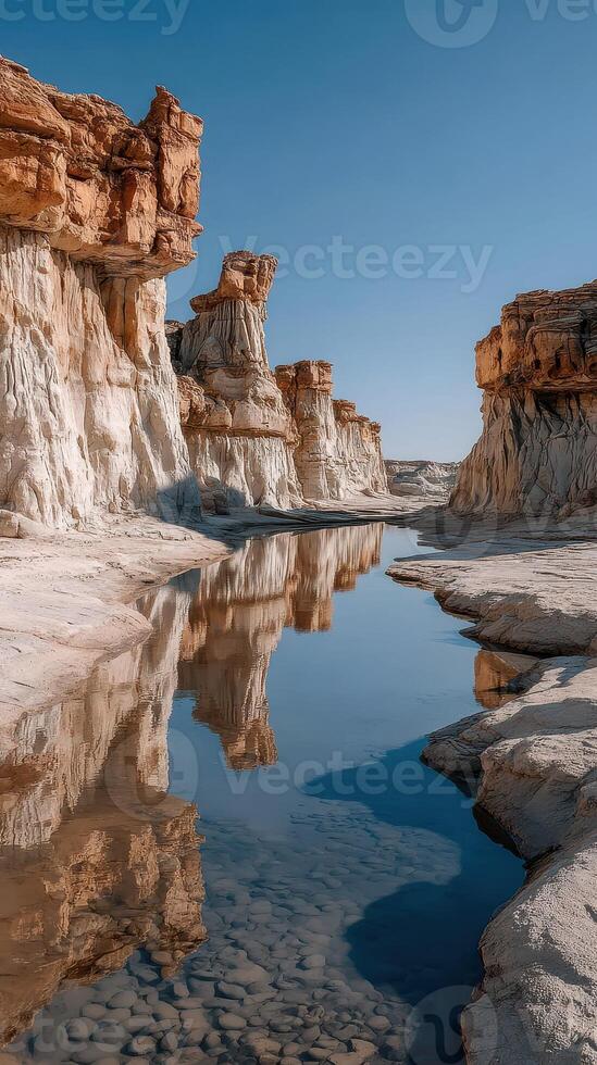 Stunning rock formations reflected in a calm river under a clear blue sky in a remote desert landscape photo